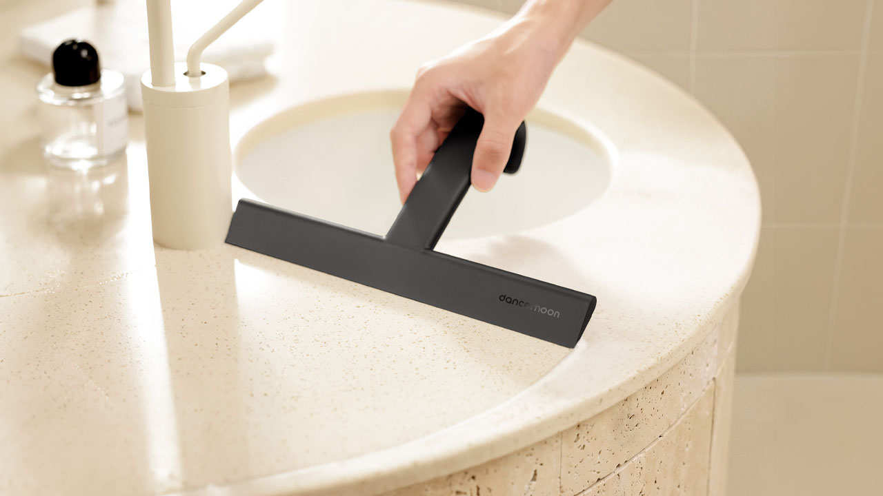 JustHang Compact Squeegee_wiping foam from a bathroom vanity